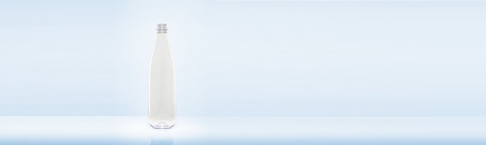 Eine transparente, leere Kunststoffflasche steht auf einer glatten Oberfläche vor einem hellblauen Hintergrund und repräsentiert nachhaltiges Behälterdesign.