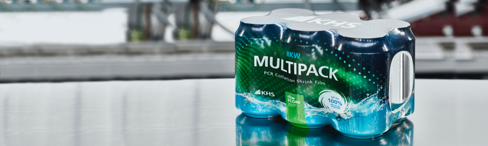Das Bild zeigt ein Multipack mit Getränkedosen, die in eine grün-blaue Schrumpffolie mit der Aufschrift "RKW Multipack" eingewickelt sind, und wirbt für die Verwendung von Folie mit bis zu 100 % recyceltem Material.